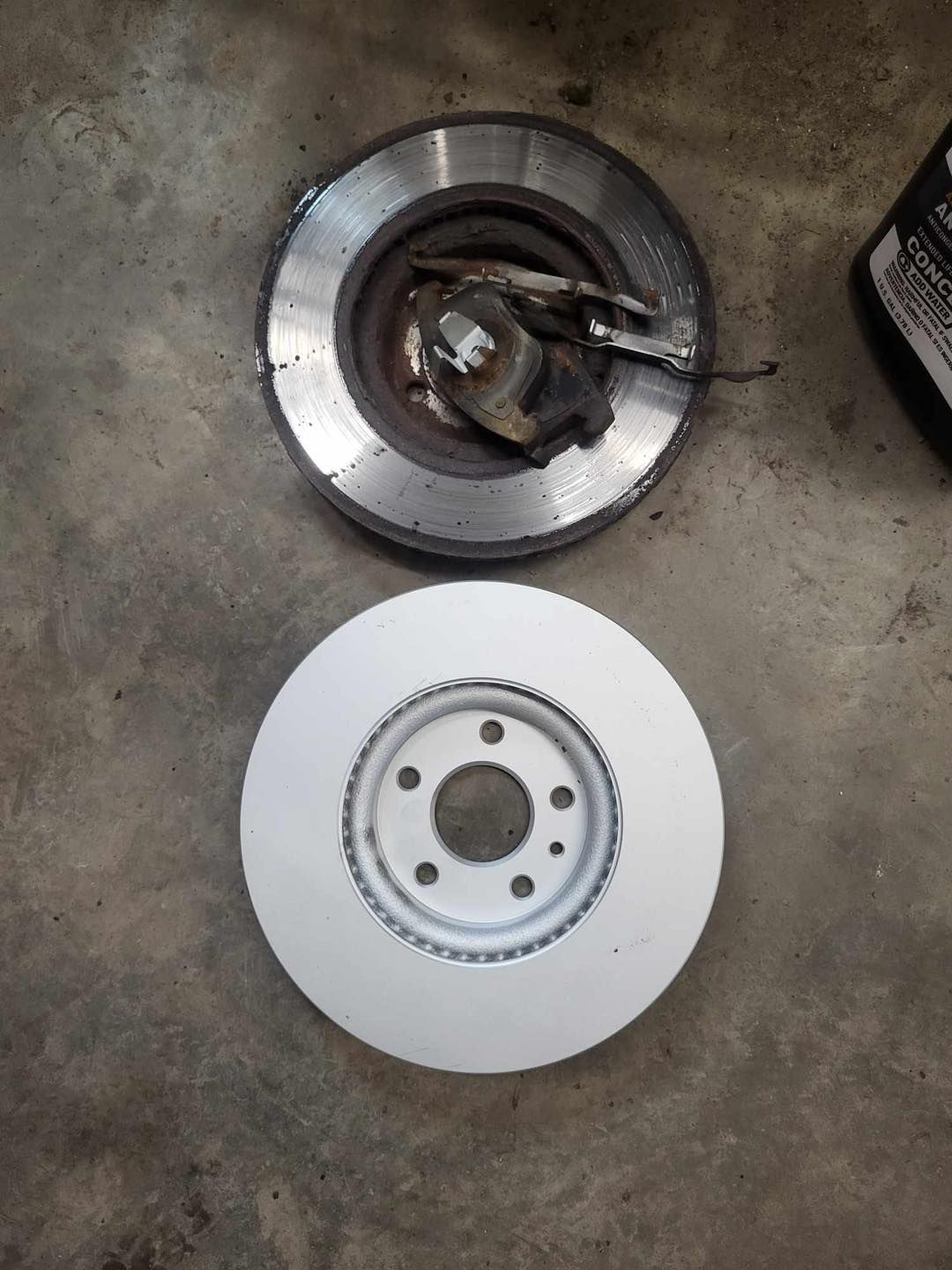 A close up of a brake disc on a concrete surface.