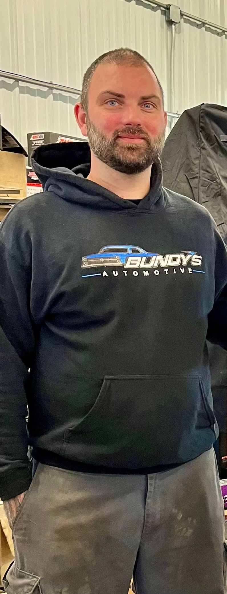 A family standing in front of a sign for bundy 's automotive