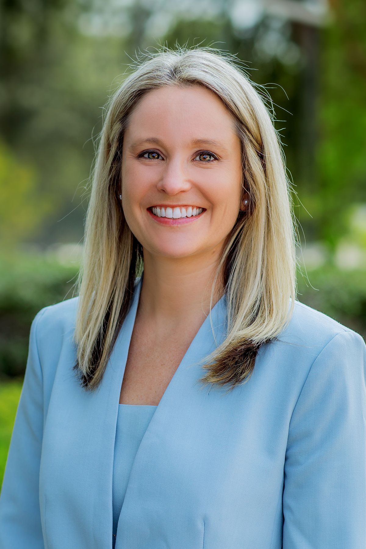 A woman in a blue jacket is smiling for the camera.
