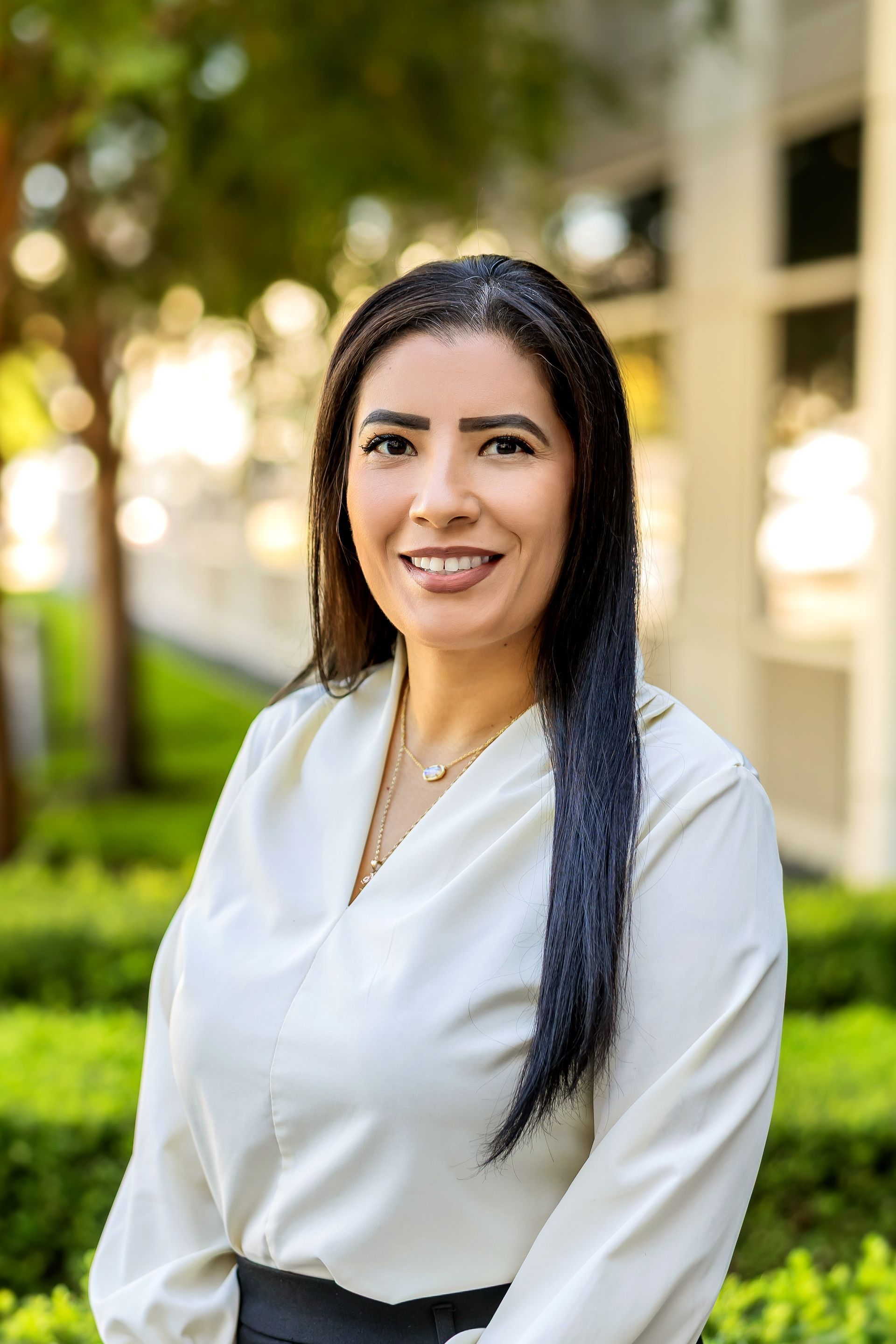 A woman in a blue jacket is smiling for the camera.