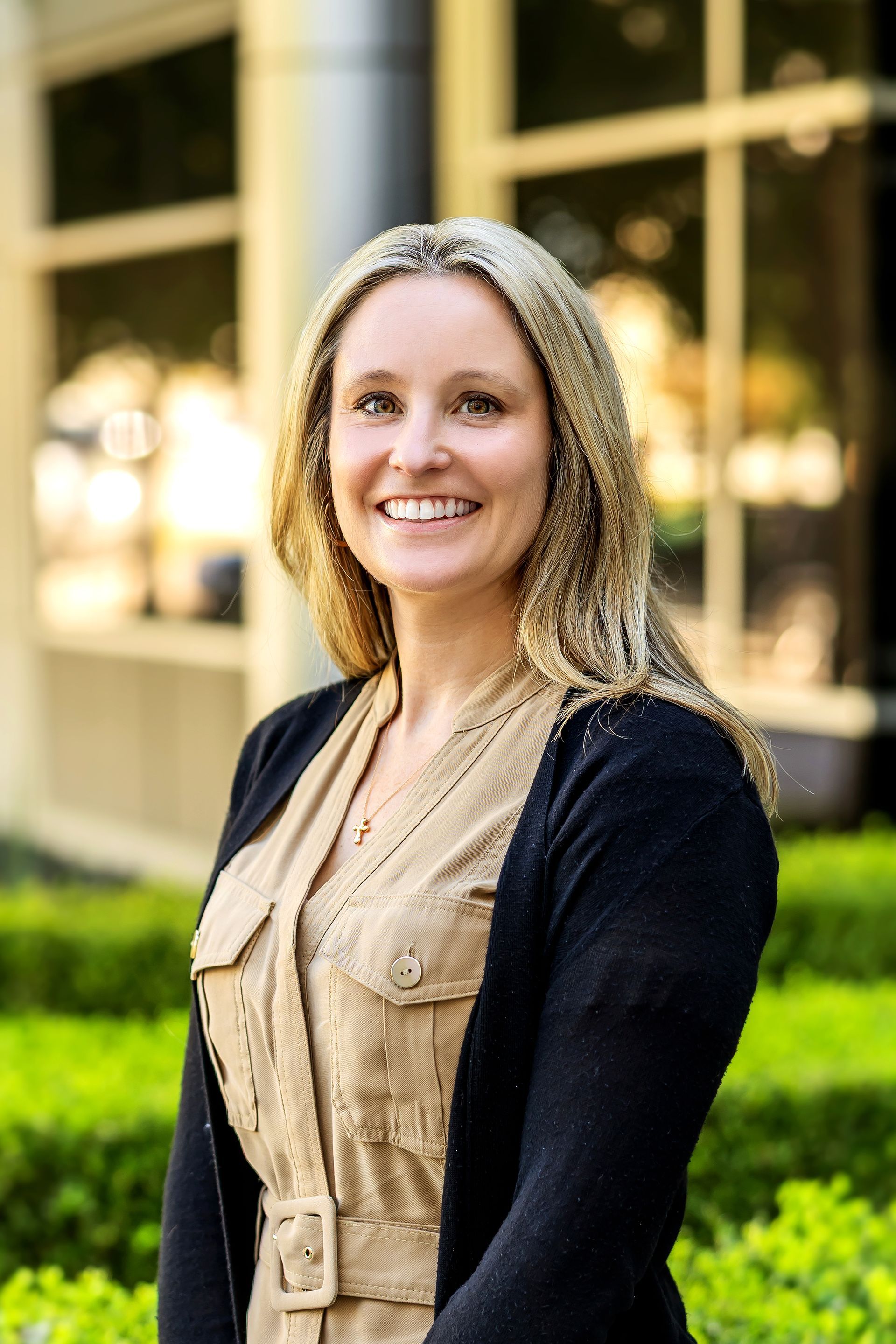 A woman in a blue jacket is smiling for the camera.