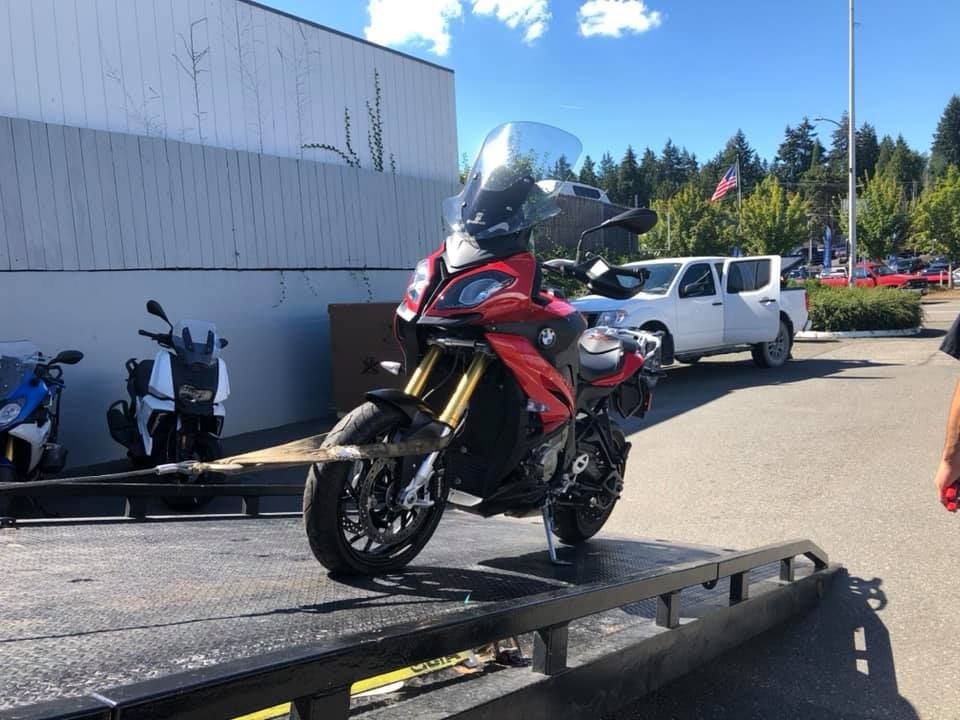 A red motorcycle is sitting on top of a tow truck.