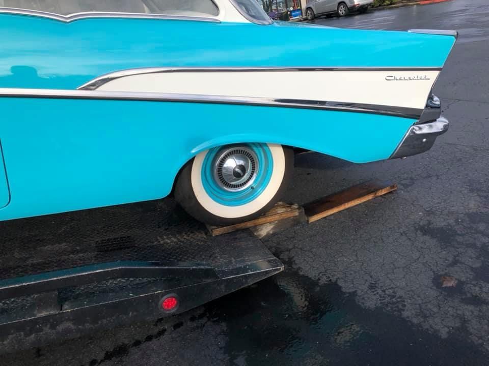 A blue and white car is sitting on a trailer.