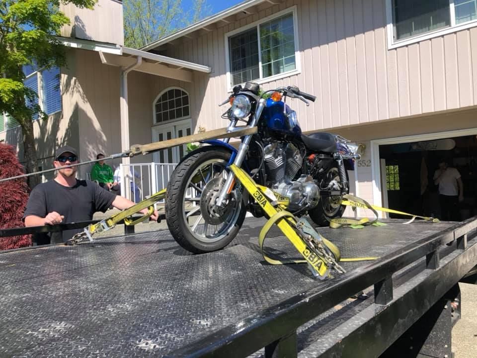 A motorcycle is sitting on top of a tow truck.
