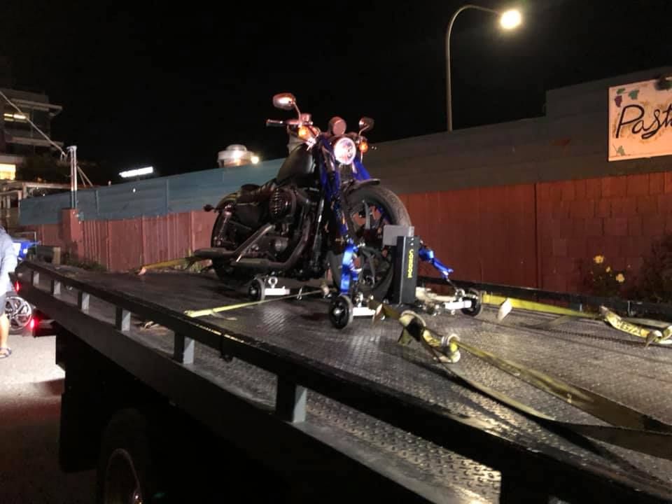 A motorcycle is sitting on top of a tow truck.