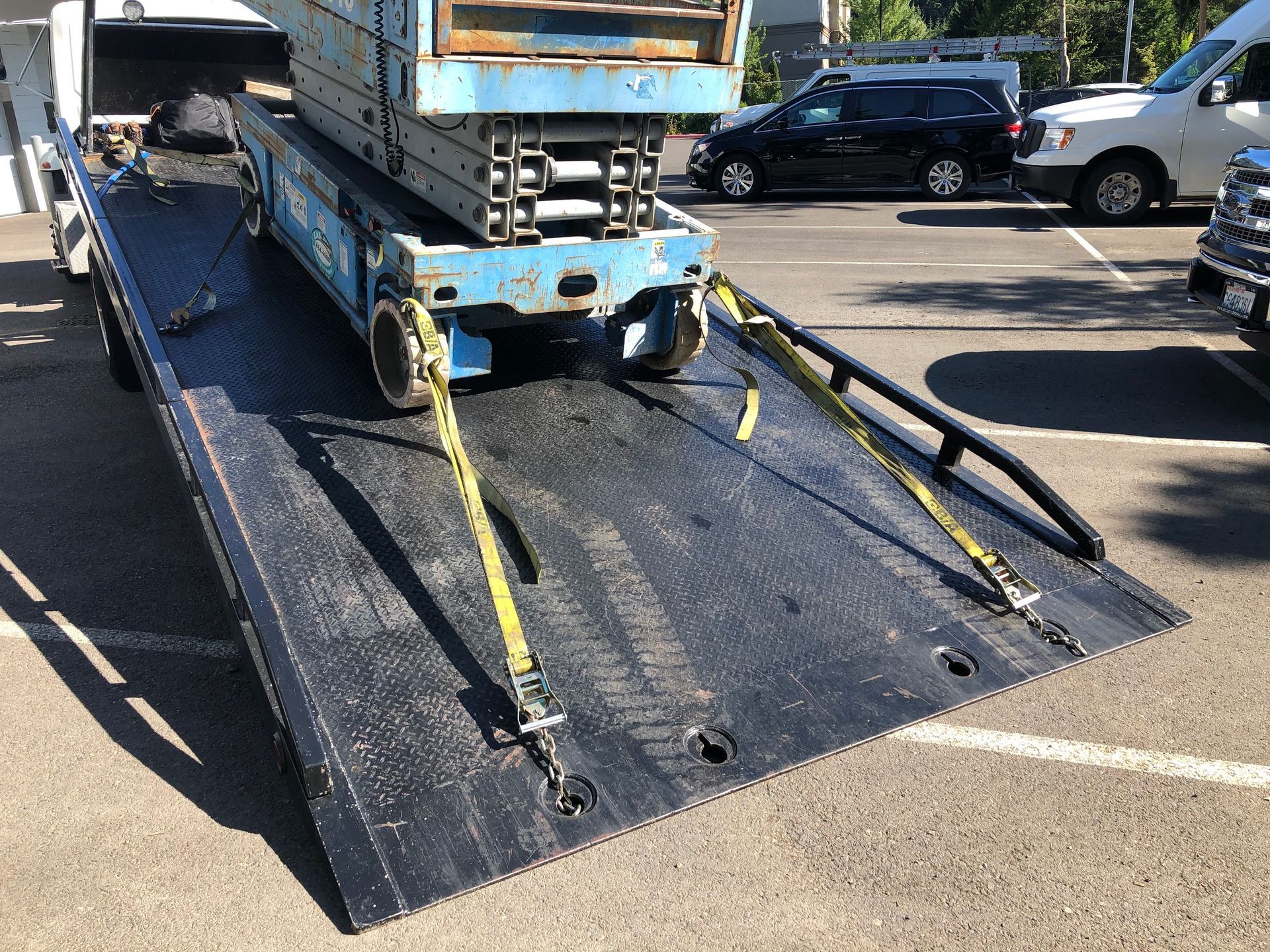 A tow truck is carrying a lift on the back of it.