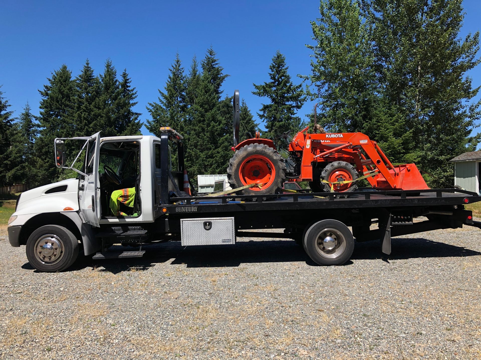 A tow truck with a tractor on the back of it