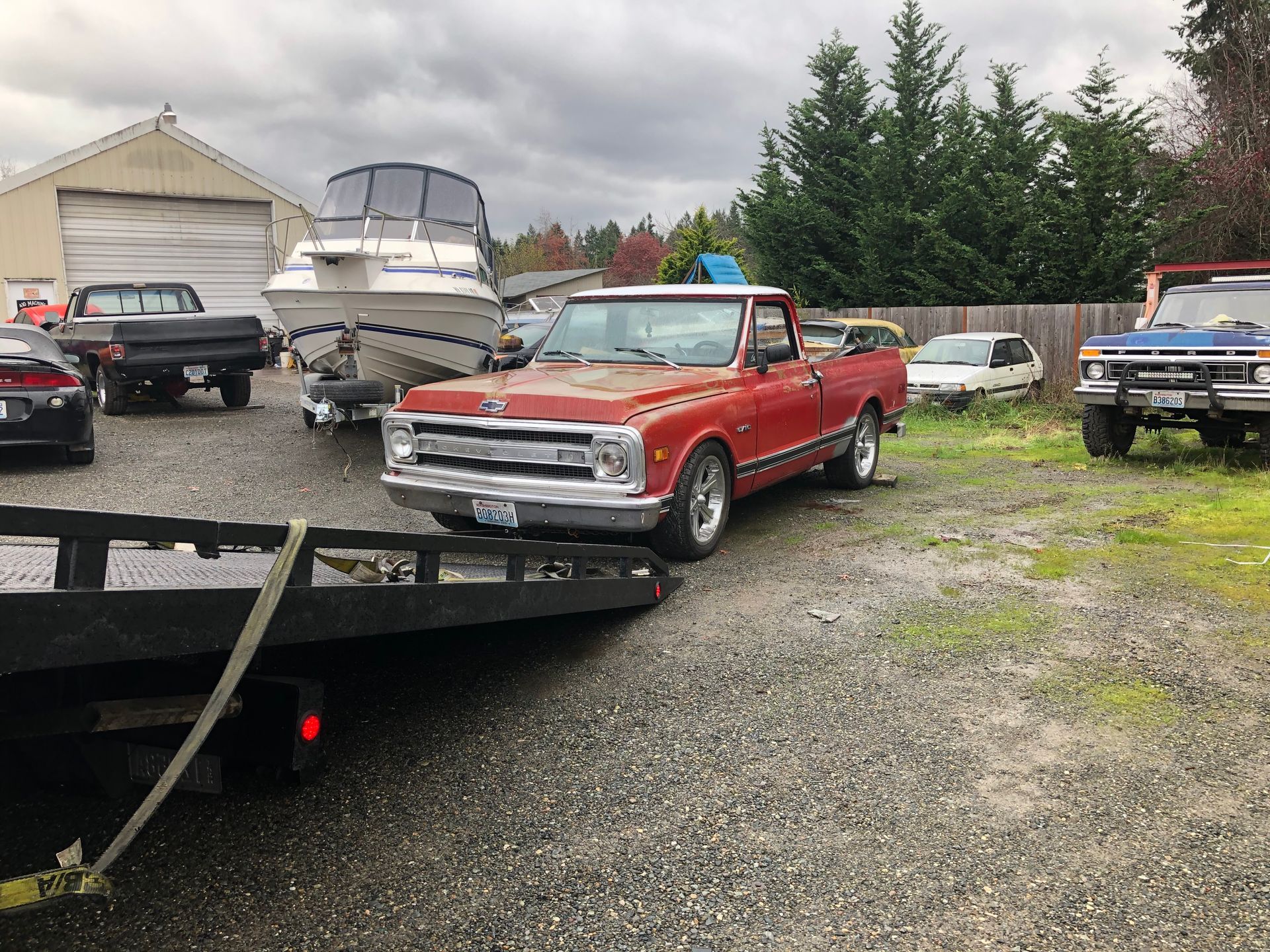 A red truck is being towed by a tow truck.