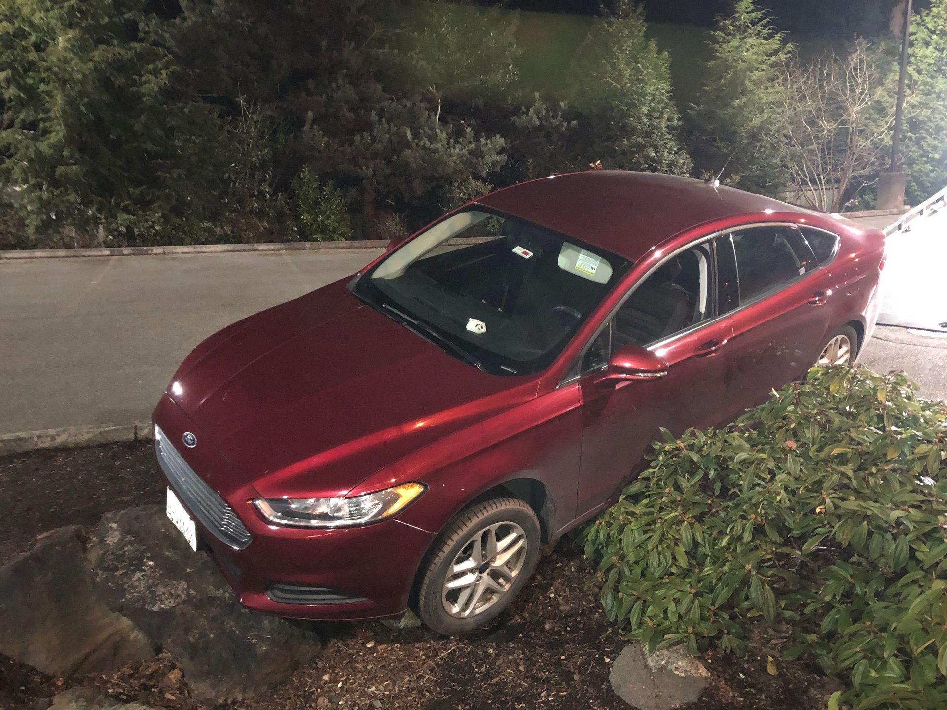 A red car is parked on the side of the road.