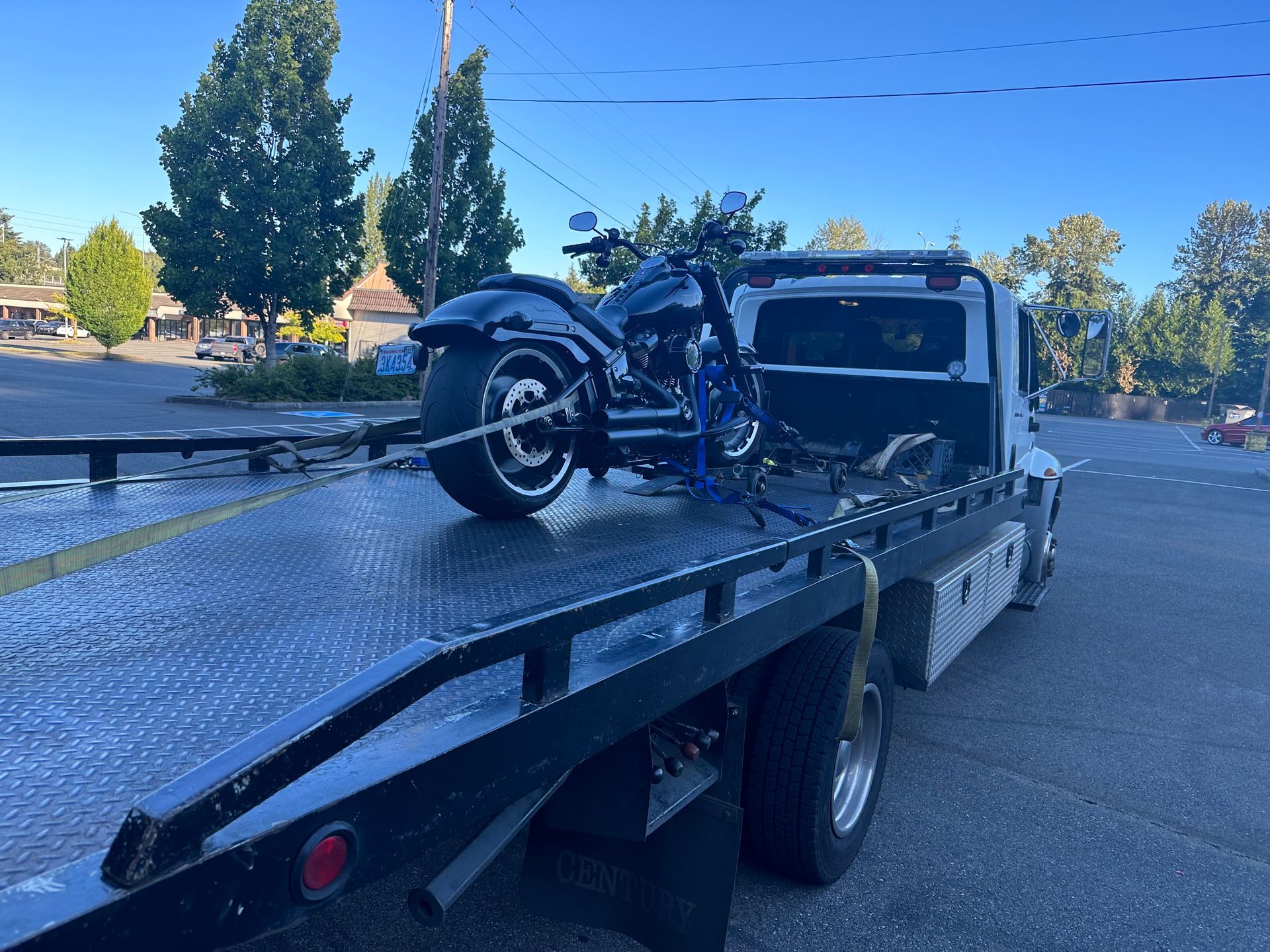 A motorcycle is sitting on top of a tow truck.