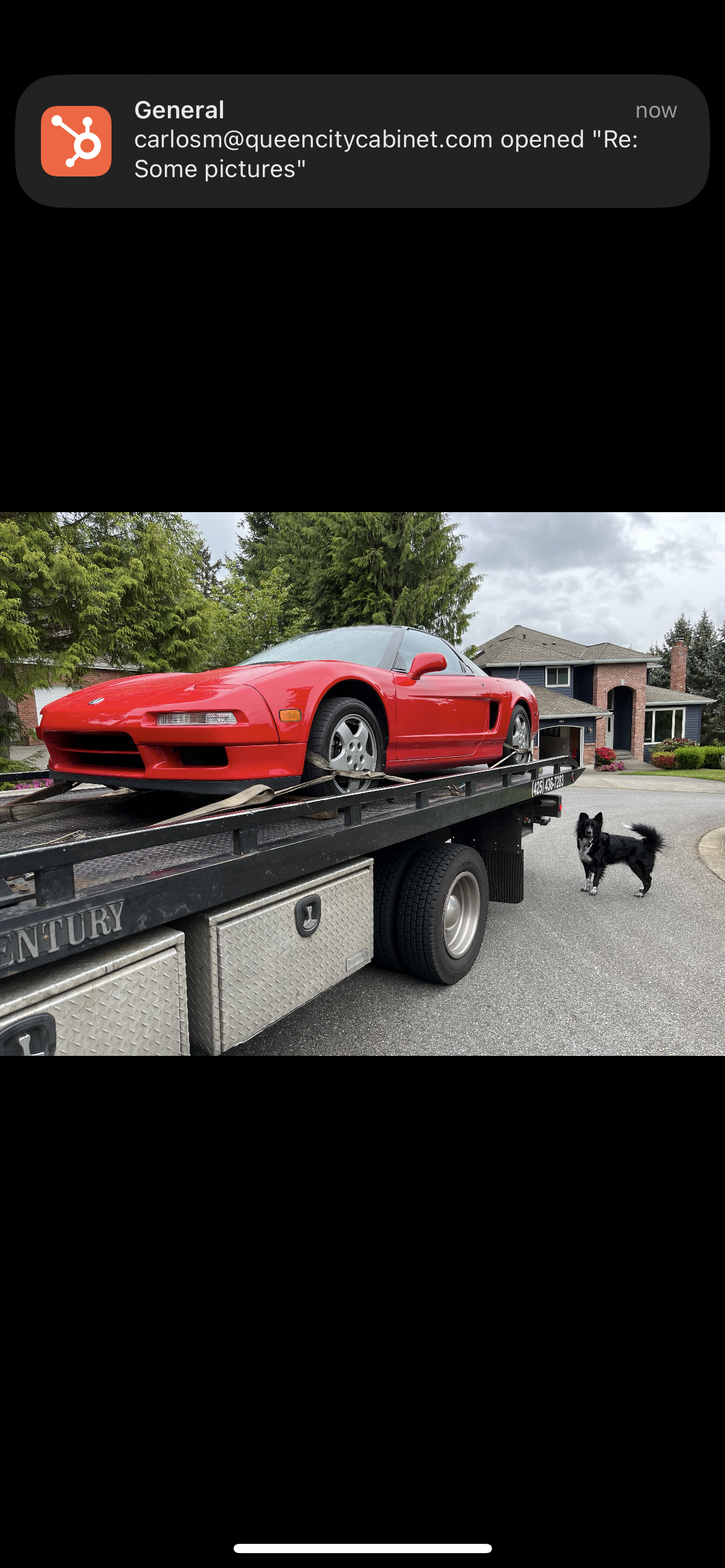 A red sports car is sitting on top of a tow truck.