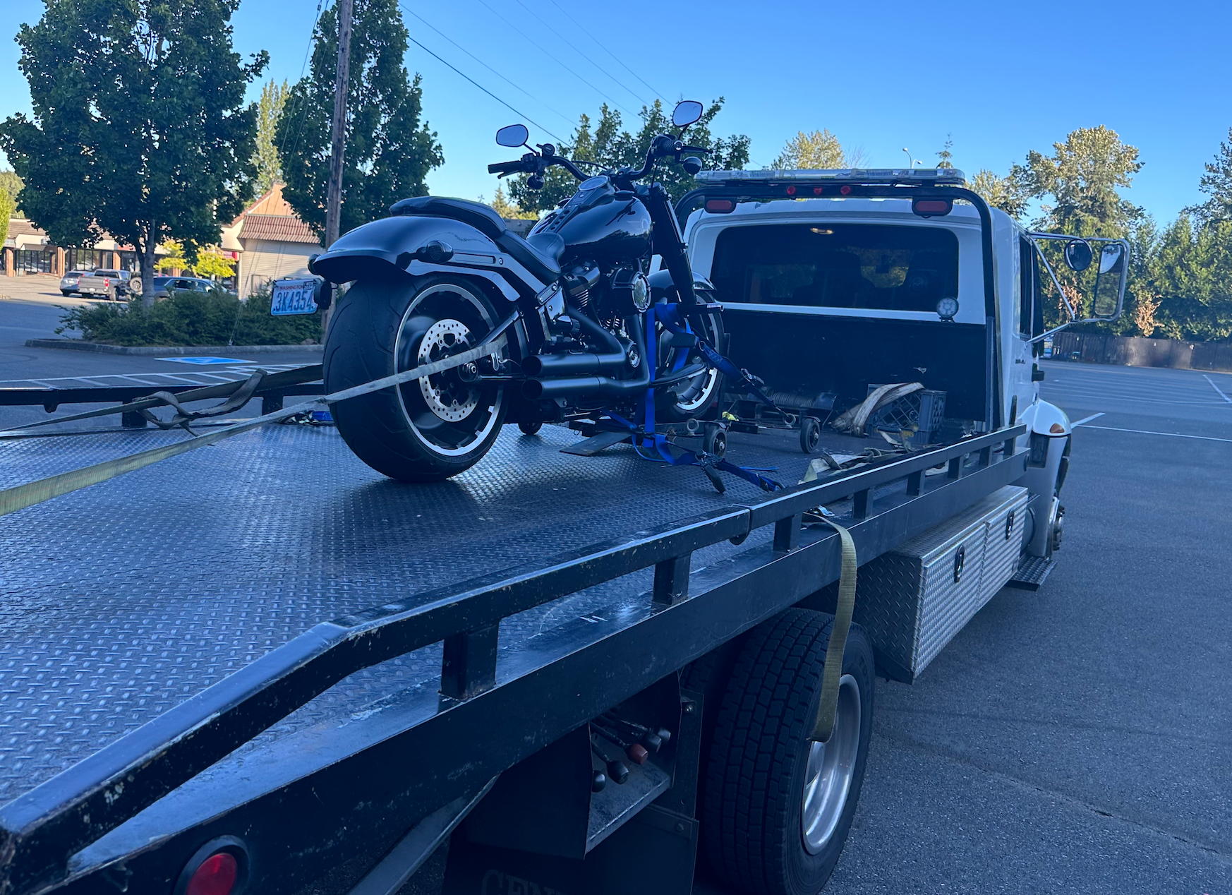 A motorcycle is sitting on top of a tow truck.