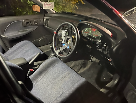 The interior of a car with a steering wheel and dashboard