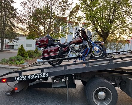 A motorcycle is sitting on top of a tow truck.