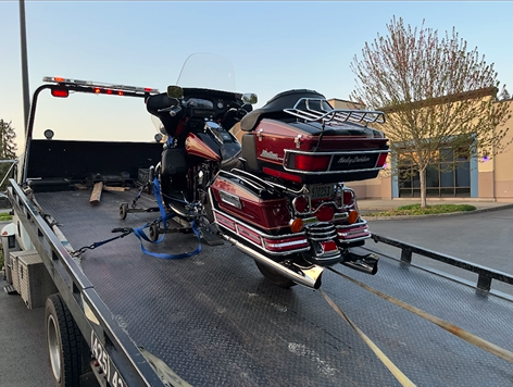 A red motorcycle is sitting on top of a tow truck.