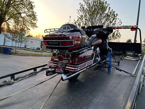 A motorcycle is sitting on top of a tow truck.