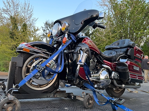 A harley davidson motorcycle is being towed on a trailer.