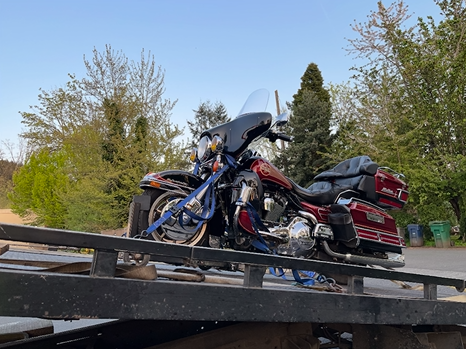 A motorcycle is sitting on top of a tow truck.