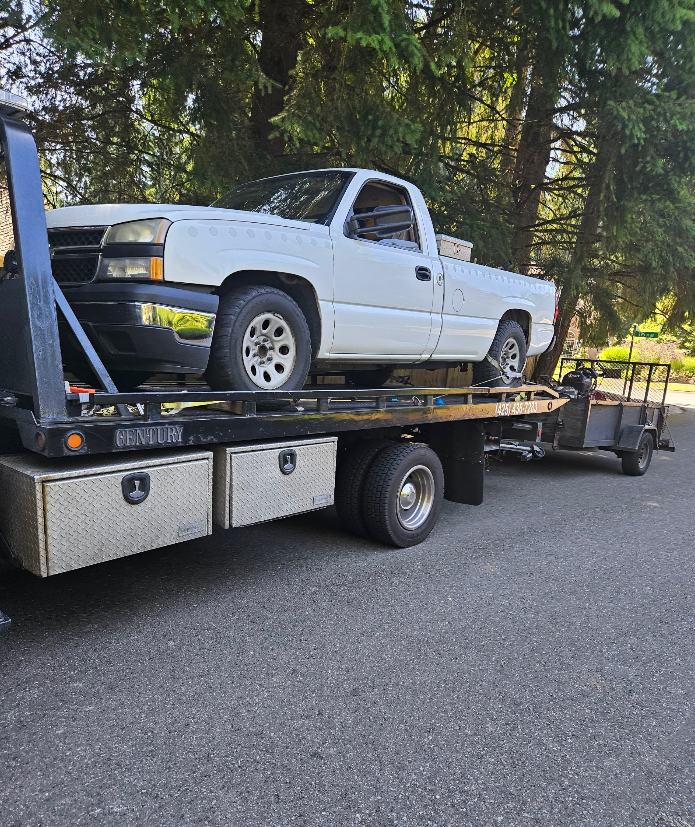 A white truck is sitting on top of a tow truck.