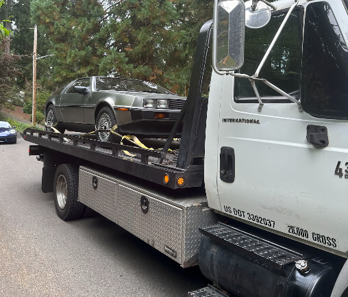 A tow truck with a car on the back of it
