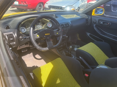 The interior of a car with yellow seats and a steering wheel.
