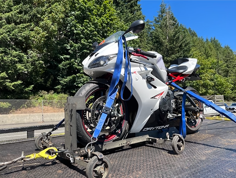 A motorcycle is being towed by a tow truck.