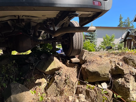 A car is parked on top of a rocky hill.