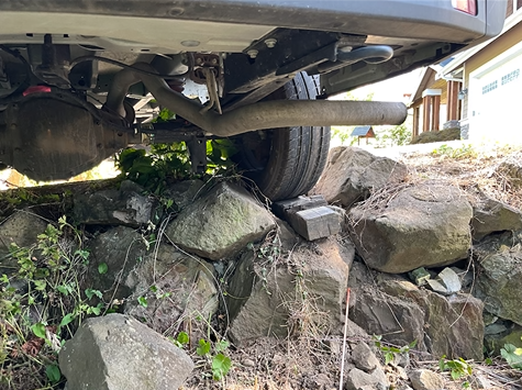 A car is sitting on top of a pile of rocks.