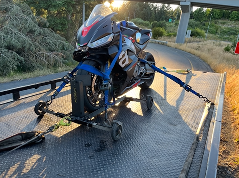 A motorcycle is sitting on top of a tow truck.