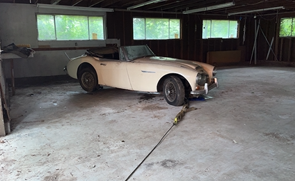 A white sports car is parked in a garage.