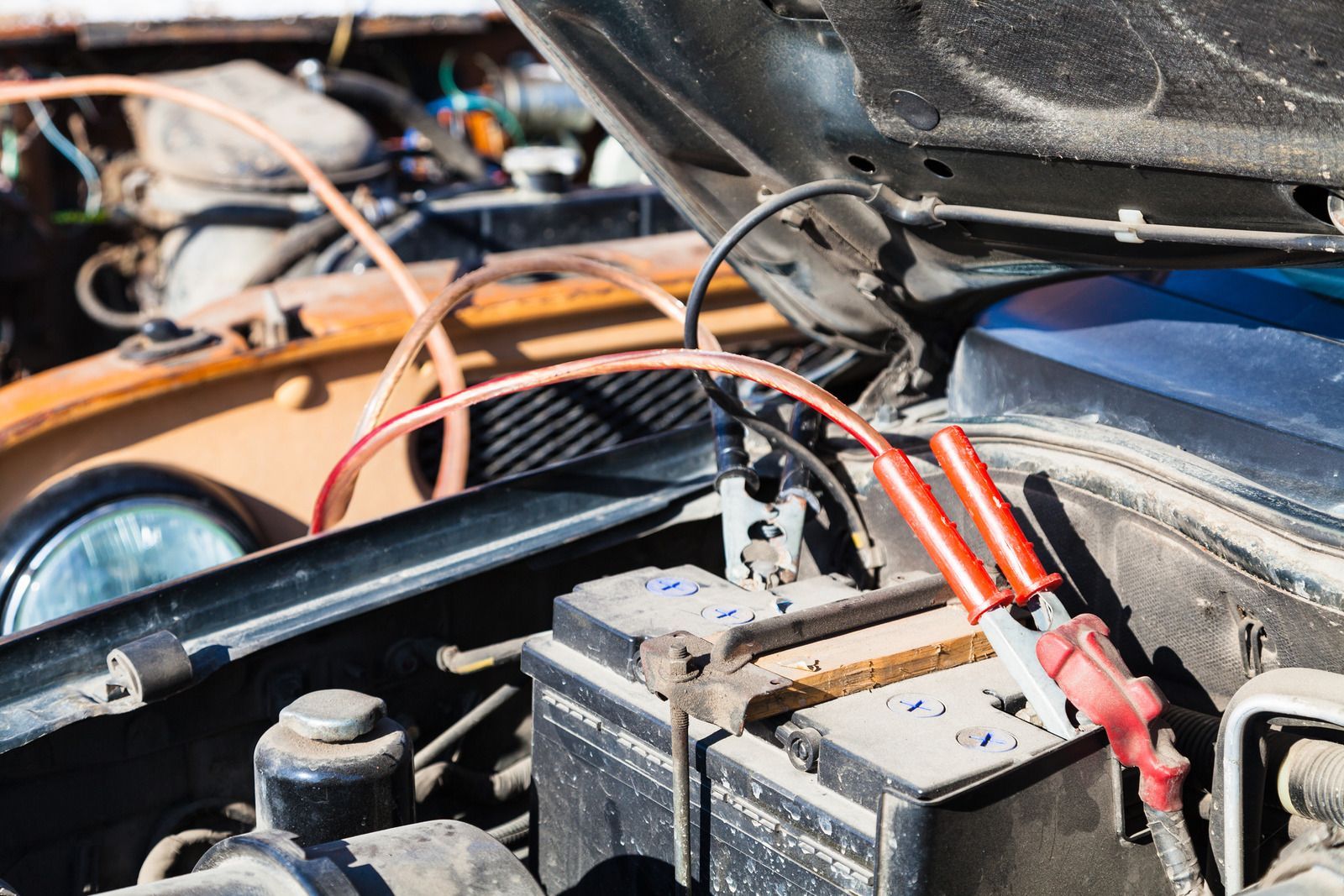 A car battery is being charged with jumper cables.