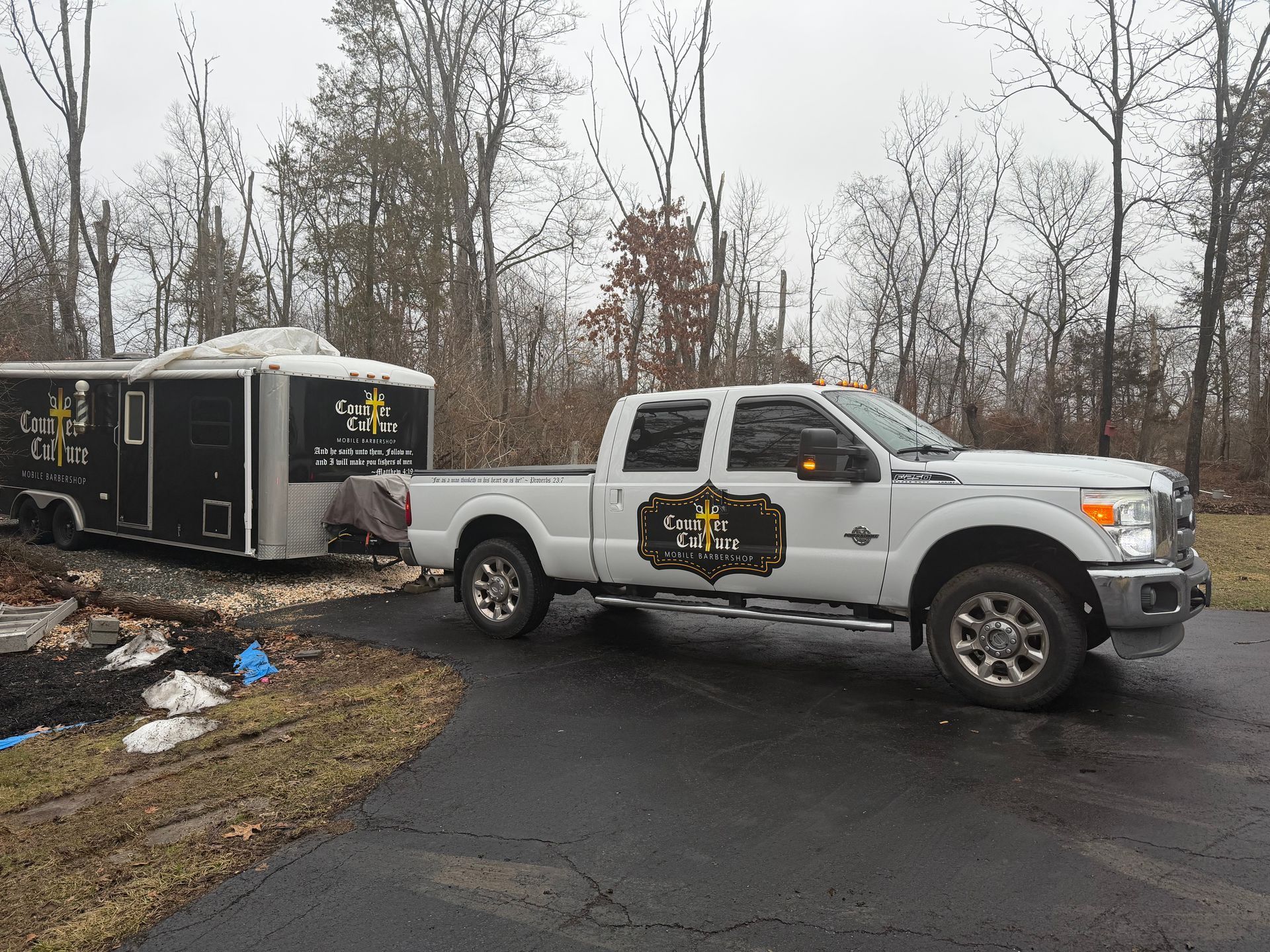 A white Ford pickup truck towing a black trailer with 