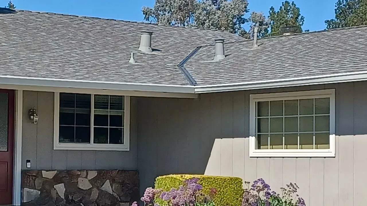 House exterior with gray roof, windows, and light gray siding.