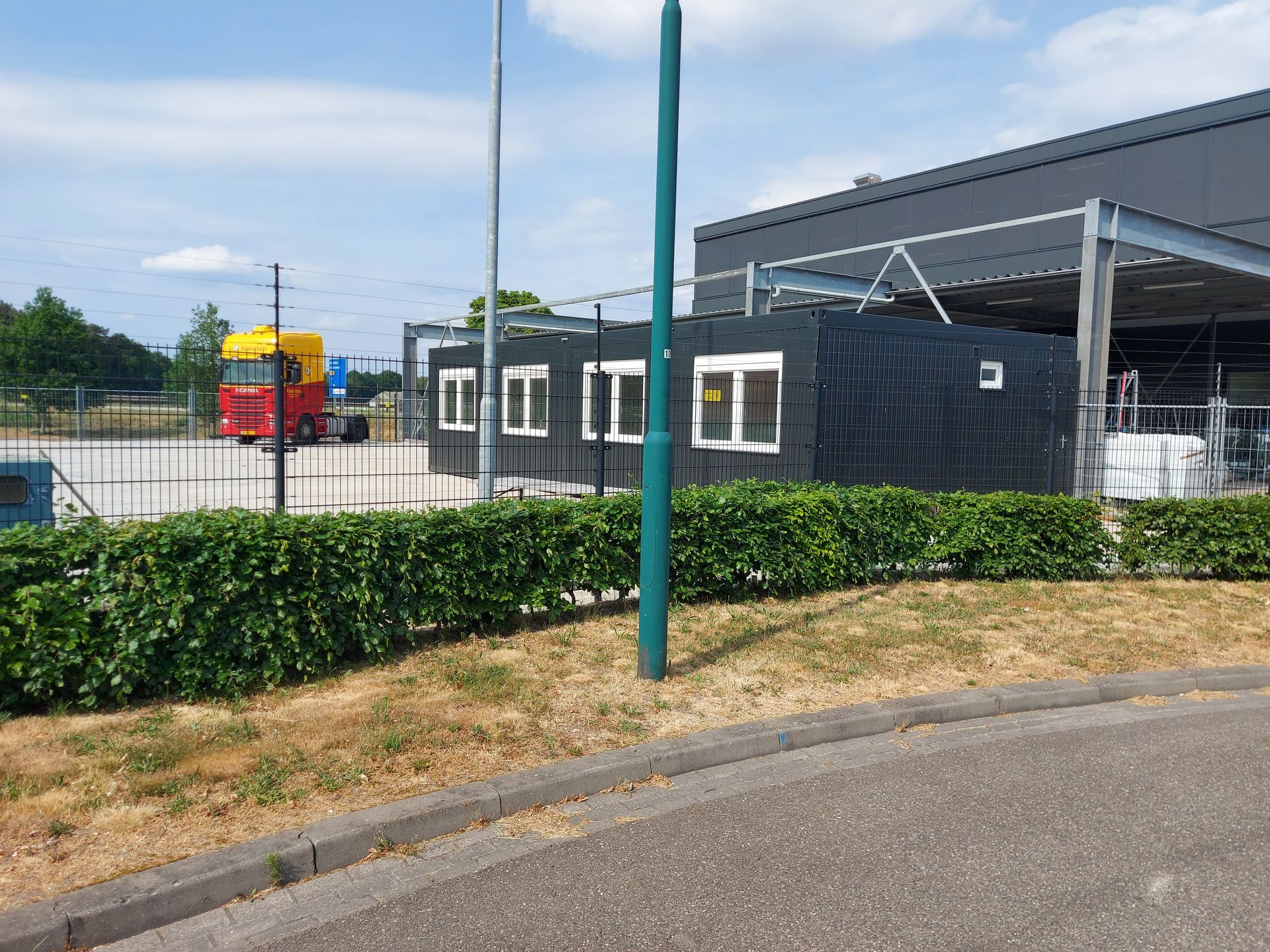 Een zeecontainer staat midden op een grasveld.