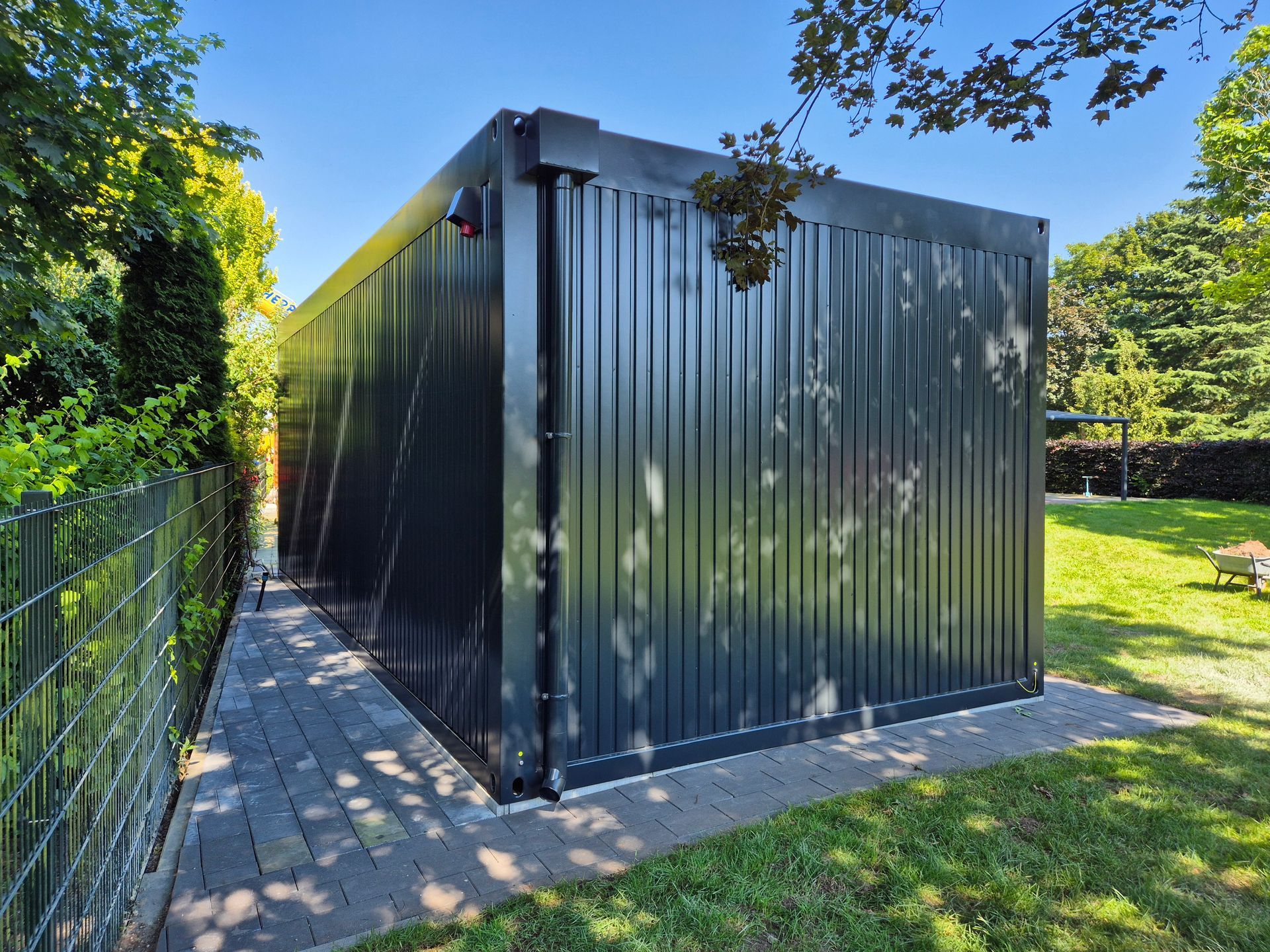 Een zeecontainer staat midden op een grasveld.