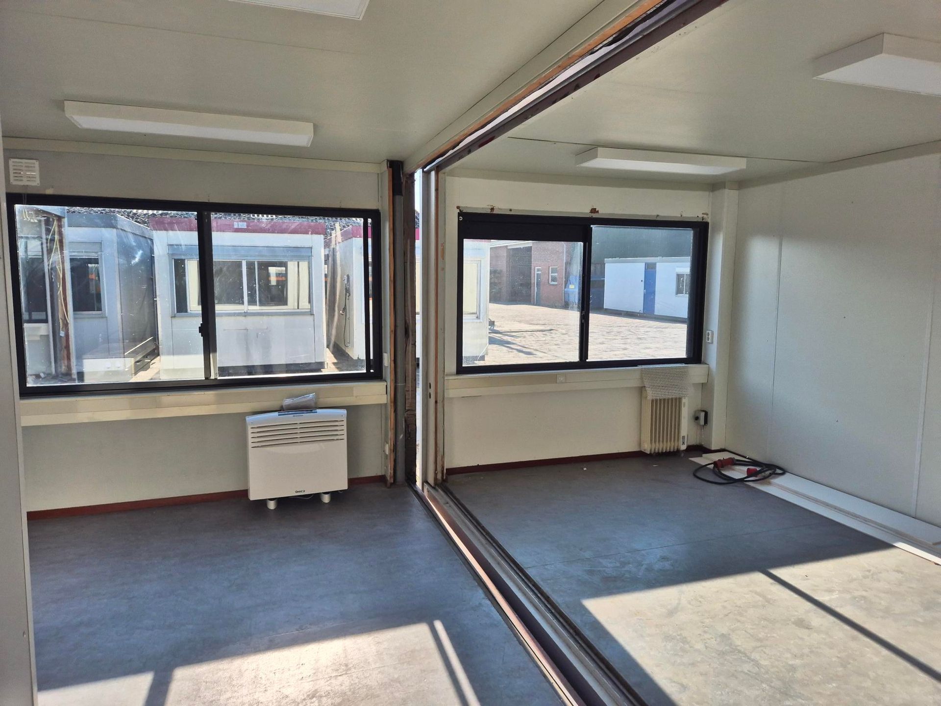 Een zeecontainer staat midden op een grasveld.