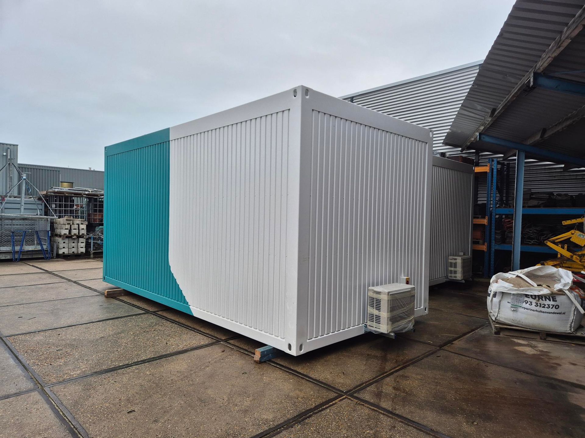 Een zeecontainer staat midden op een grasveld.