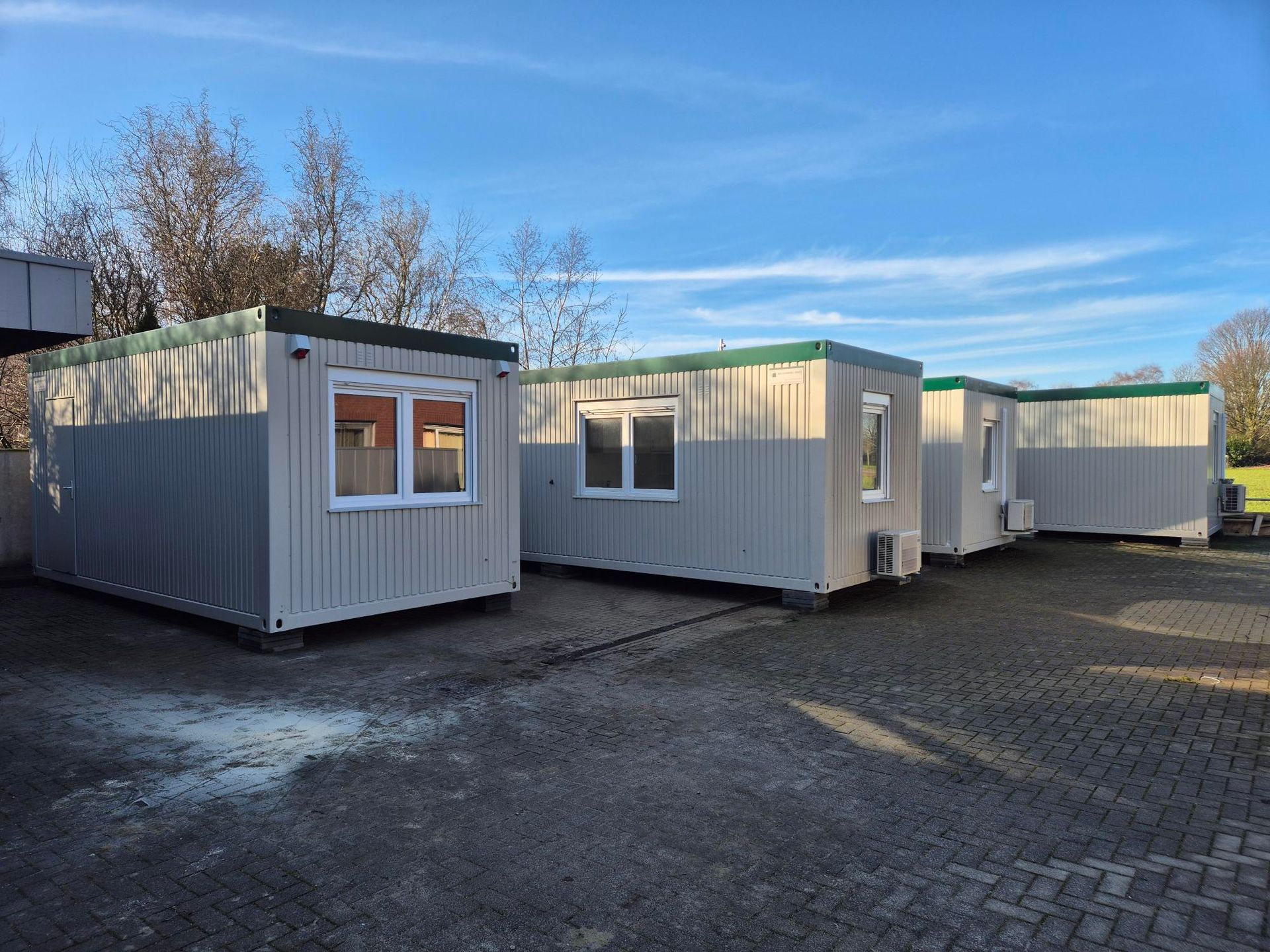 Een zeecontainer staat midden op een grasveld.