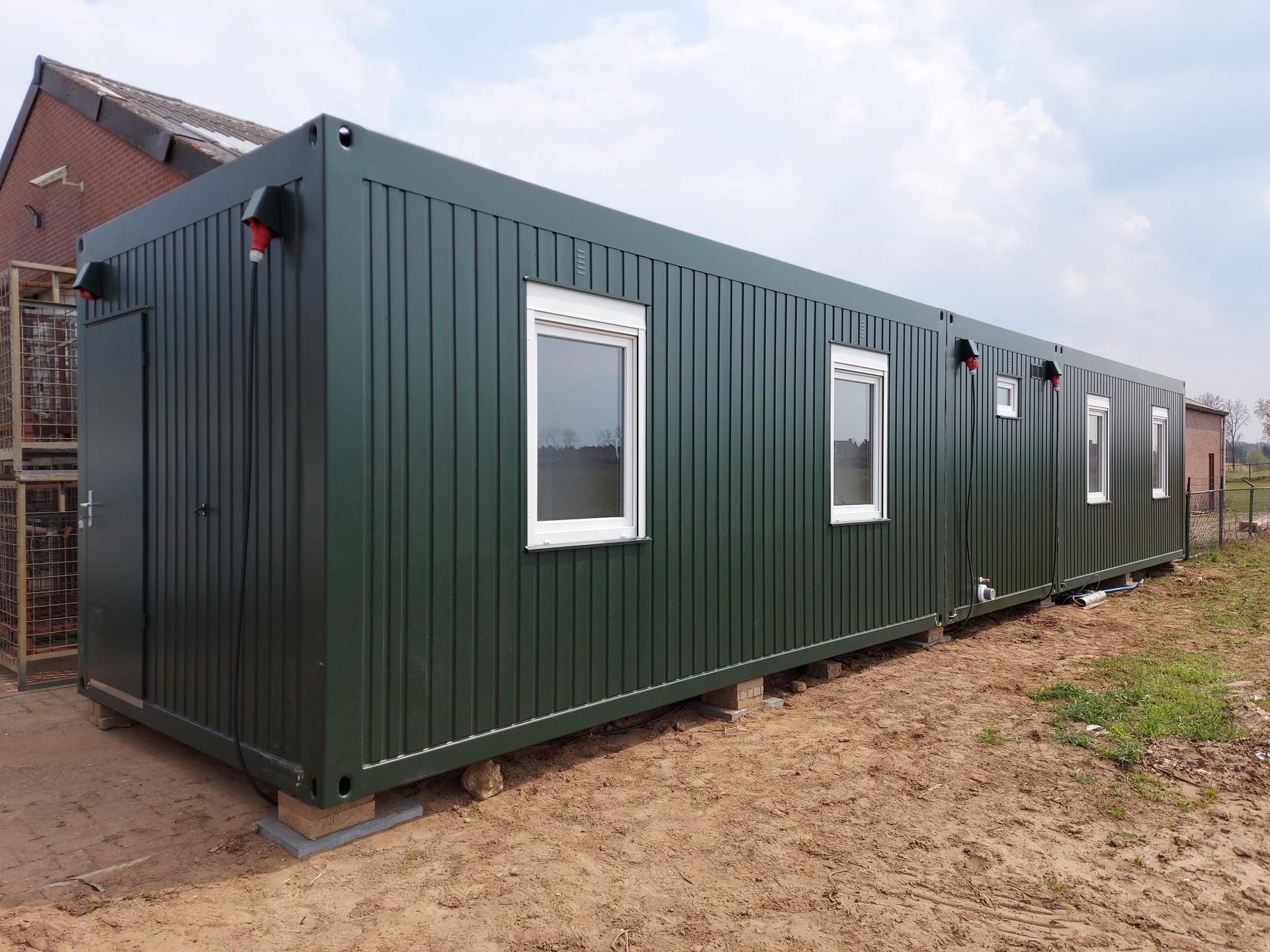 Een zeecontainer staat midden op een grasveld.