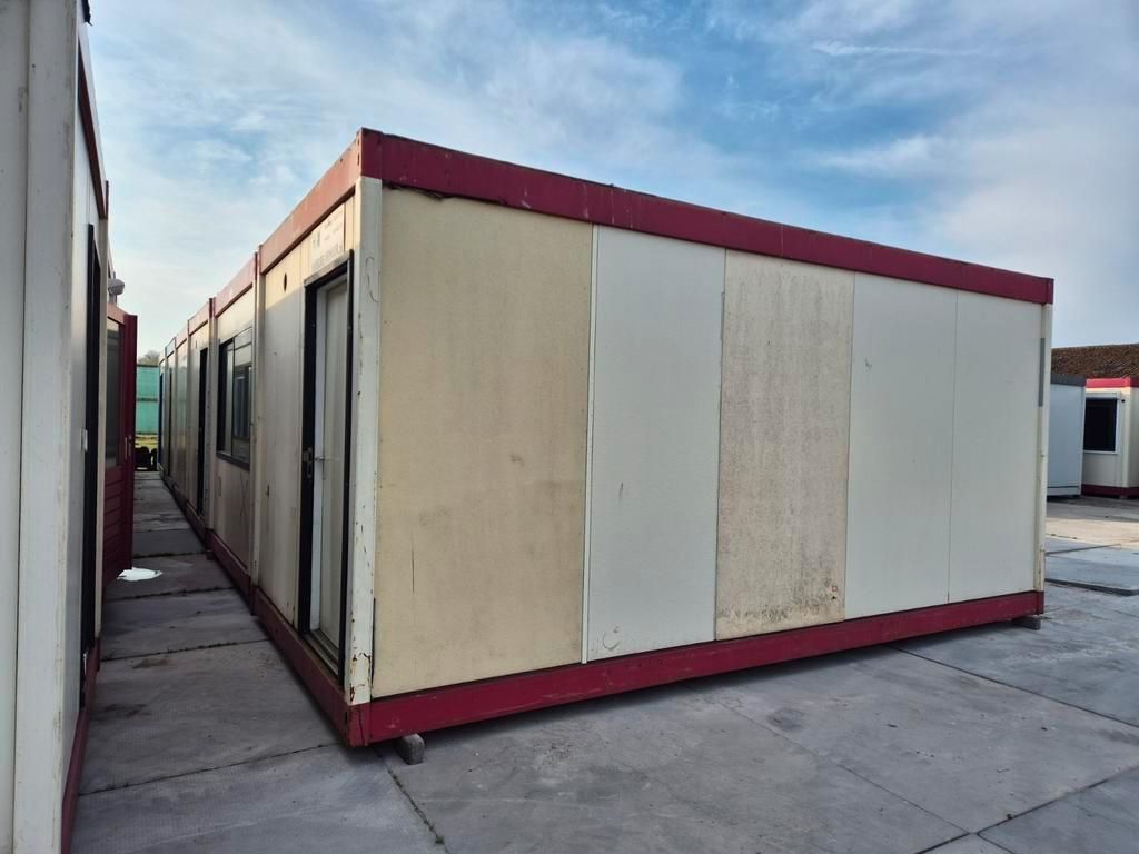 Een rij containers staat opgesteld op een parkeerplaats