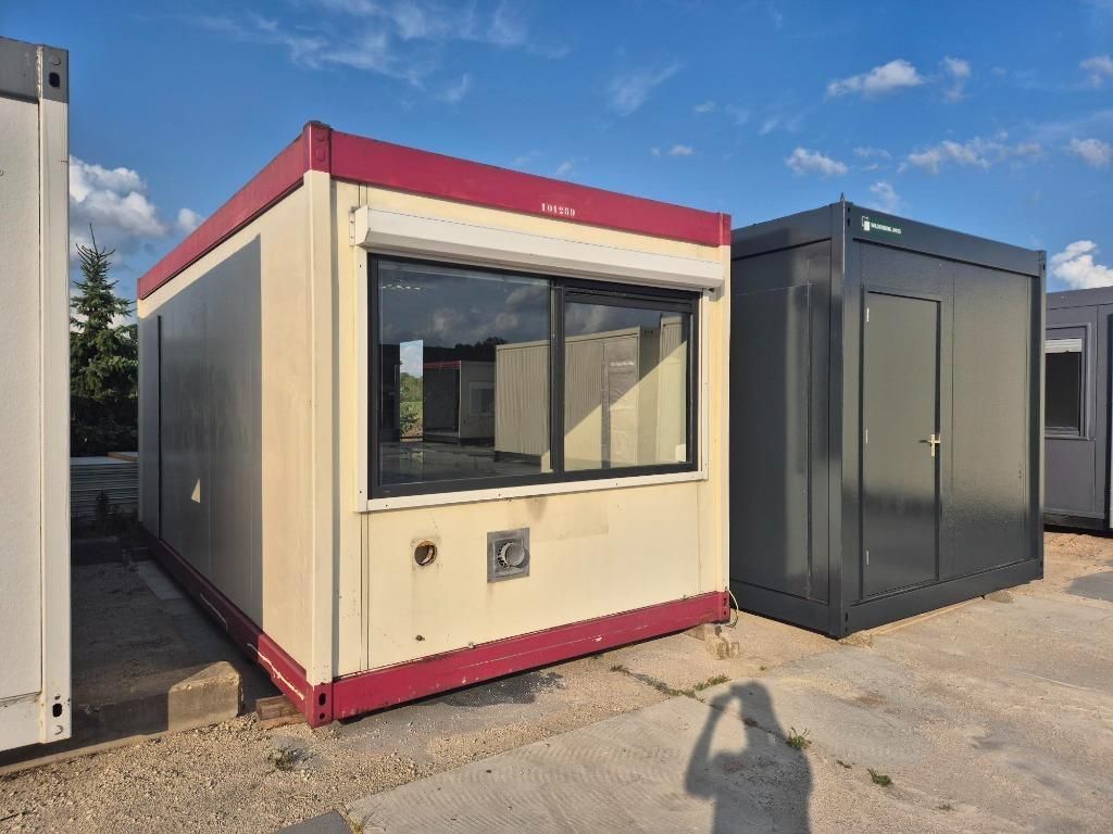 Een rij zeecontainers staat op een parkeerplaats opgesteld.