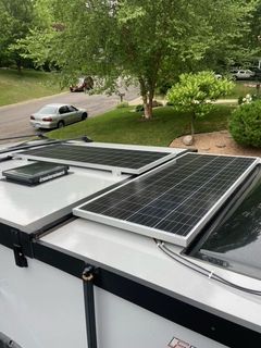 Camper with a mini solar module roof standing in the green meadow