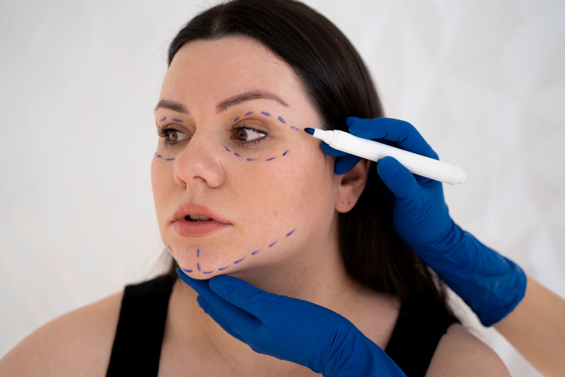 A woman is getting a plastic surgery on her face.