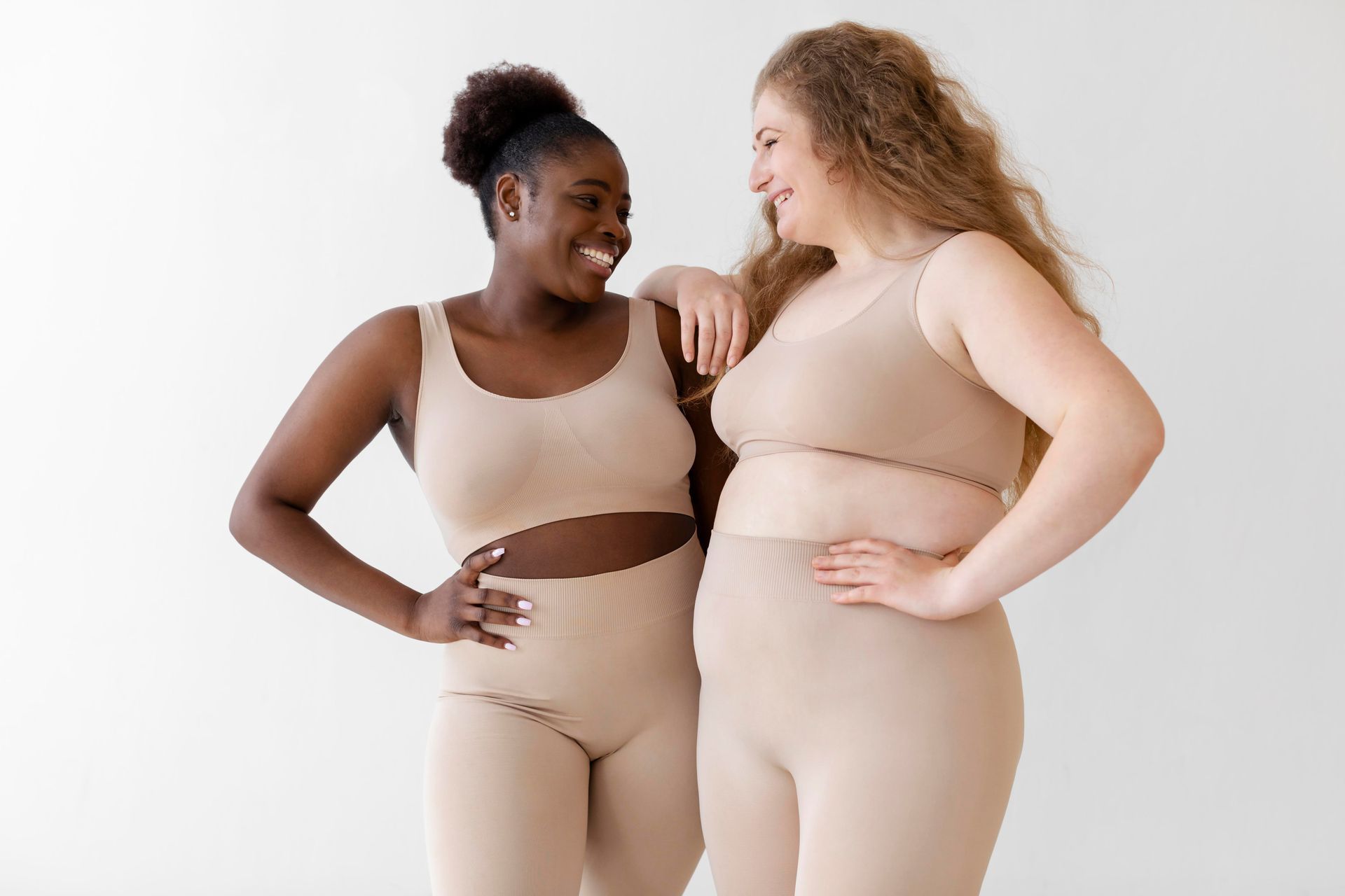 Two women are standing next to each other and smiling.