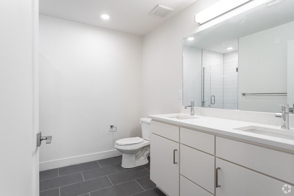 a bathroom with a toilet , sink and mirror .