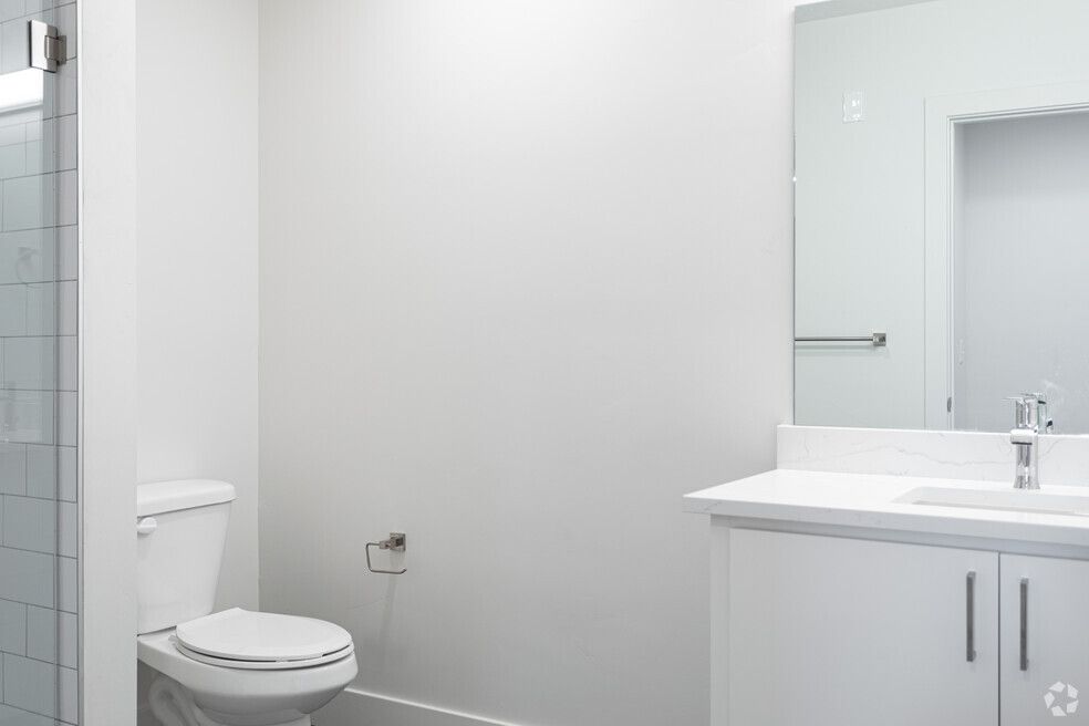 a bathroom with a toilet , sink and mirror .