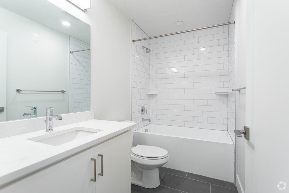 a bathroom with a sink , toilet , bathtub and mirror .