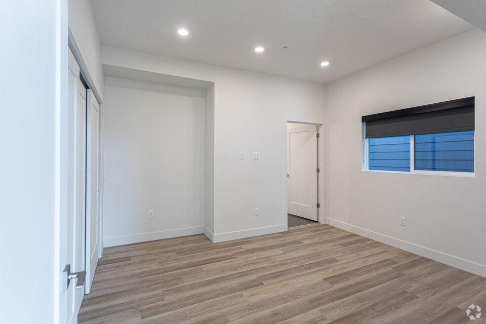 a large empty room with hardwood floors and a window .
