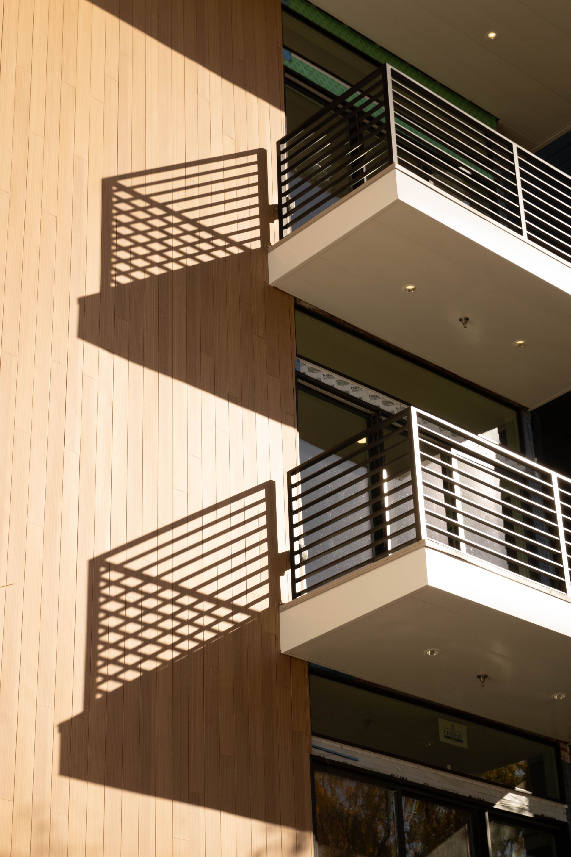a balcony on the side of a building casts a shadow