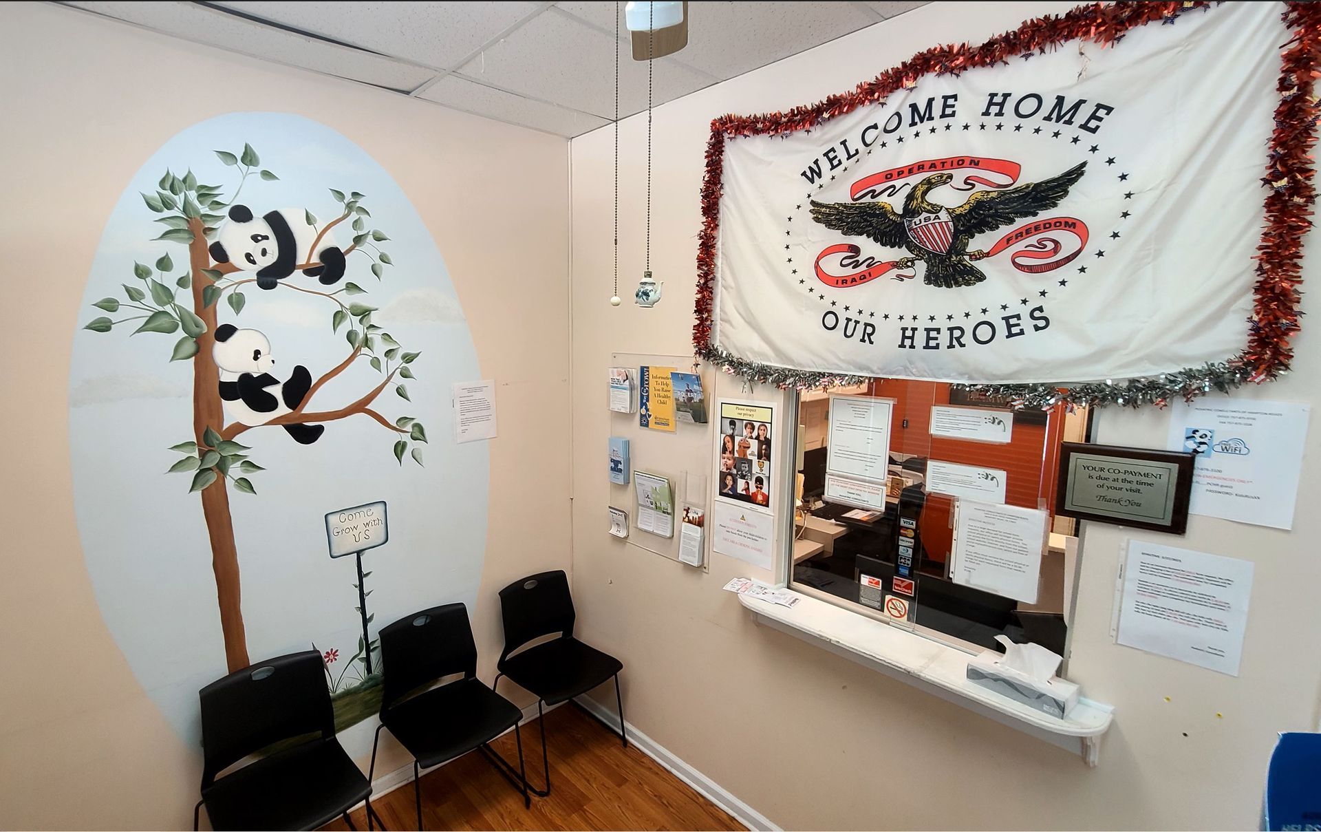 Waiting area with panda mural, chairs, desk, and 